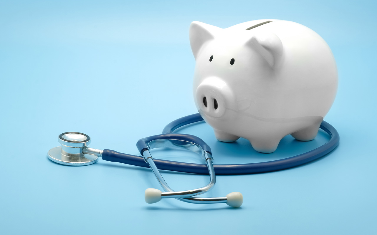 A stethoscope around a piggy bank